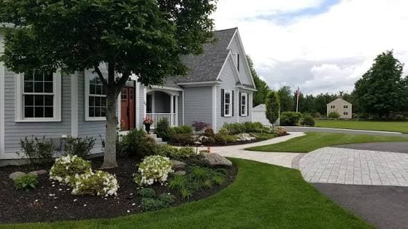 Landscaped home with foundation plantings, stone edging, and a curved walk