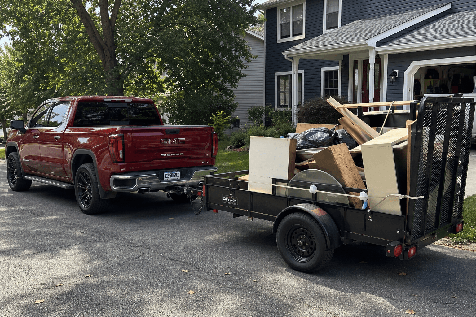 Truck and utility trailer loaded for a residential junk removal job